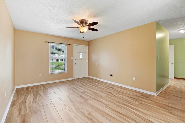 interior space featuring ceiling fan, light hardwood / wood-style flooring, and a textured ceiling