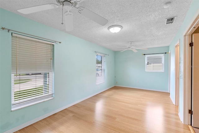 unfurnished room with a textured ceiling and light hardwood / wood-style flooring