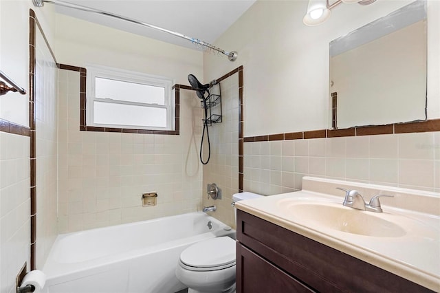 full bathroom with vanity, toilet, tile walls, and tiled shower / bath