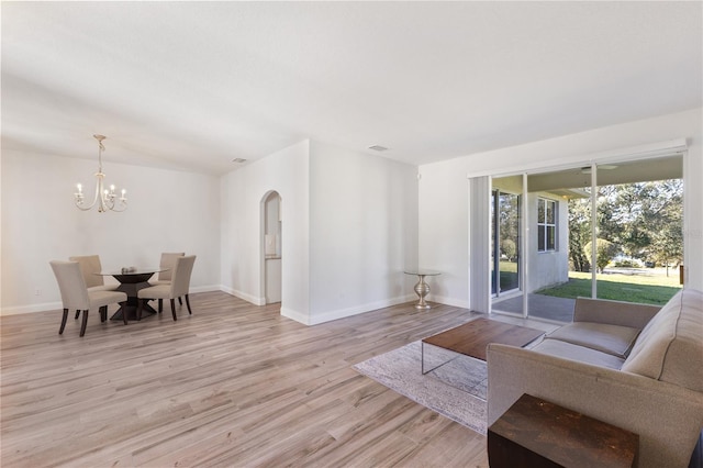 living room with a chandelier and light hardwood / wood-style flooring