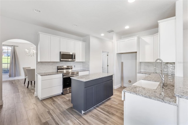 kitchen with sink, light wood-type flooring, white cabinetry, and stainless steel appliances