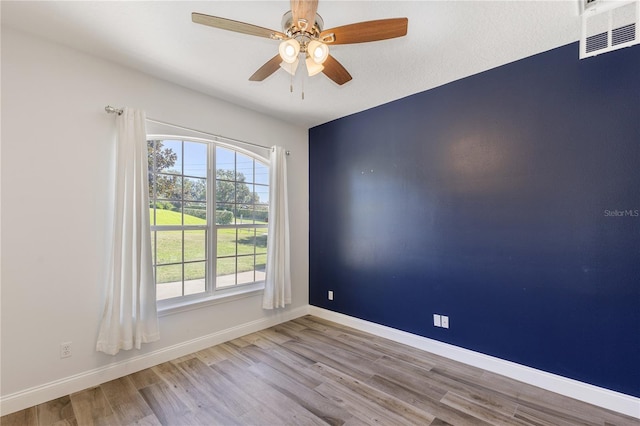 spare room featuring a textured ceiling, light wood-type flooring, and ceiling fan