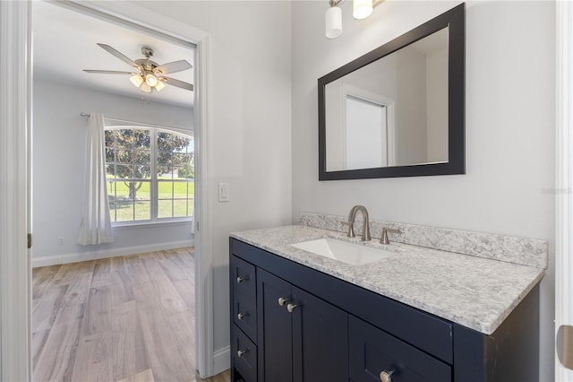 bathroom with ceiling fan, vanity, and wood-type flooring