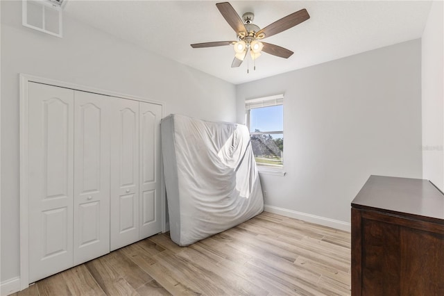 unfurnished bedroom featuring a closet, ceiling fan, and light hardwood / wood-style flooring