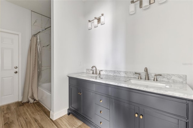 bathroom with wood-type flooring, vanity, and shower / tub combo with curtain