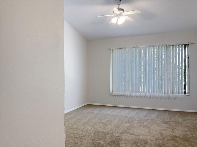 carpeted spare room featuring ceiling fan