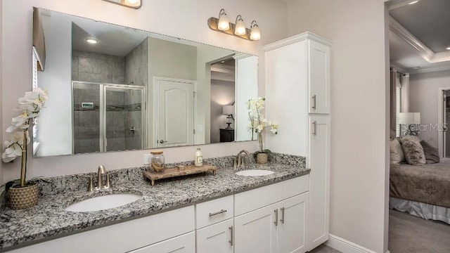 bathroom with vanity, a shower with shower door, and ornamental molding