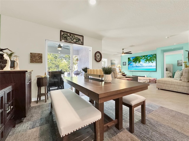 tiled dining space featuring ceiling fan and a textured ceiling