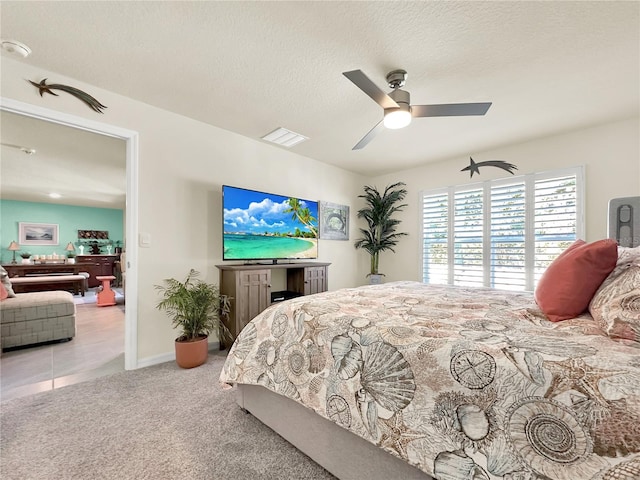 bedroom with light carpet, a textured ceiling, and ceiling fan