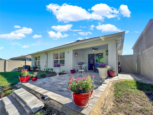 rear view of property with a lawn, a patio area, and ceiling fan