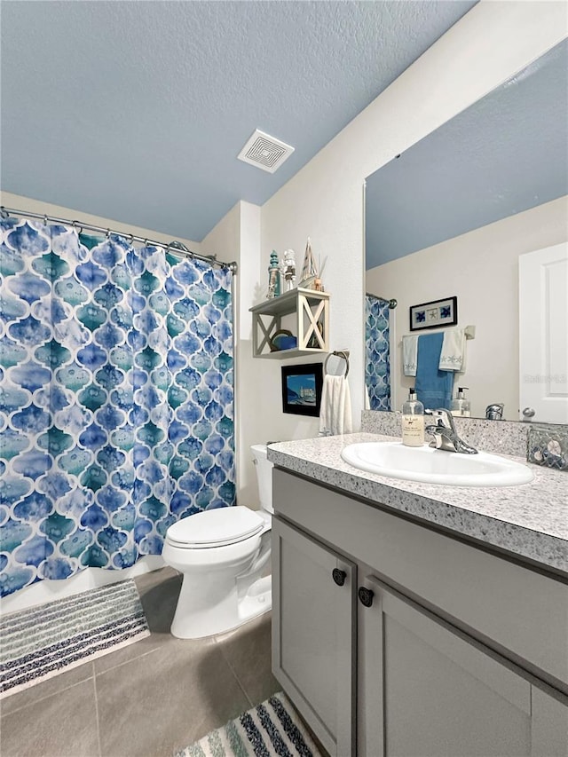 bathroom with vanity, toilet, and a textured ceiling