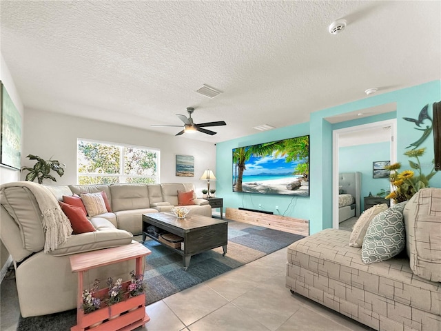 living room featuring a textured ceiling, ceiling fan, and light tile patterned flooring