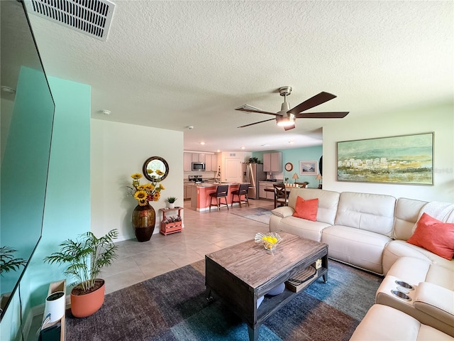 7729 Rosewood Garden Loop, Tampa, FL 33637 - living room featuring light tile patterned floors, a ceiling fan, and a textured ceiling