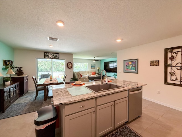 7729 Rosewood Garden Loop, Tampa, FL 33637 - kitchen featuring stainless steel dishwasher, open floor plan, light tile patterned floors, a center island with sink, and a textured ceiling