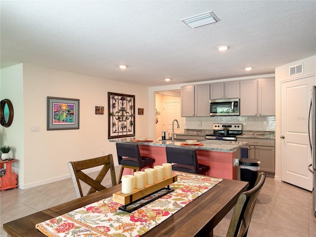 7729 Rosewood Garden Loop, Tampa, FL 33637 - dining area featuring light tile patterned floors, a textured ceiling, and recessed lighting