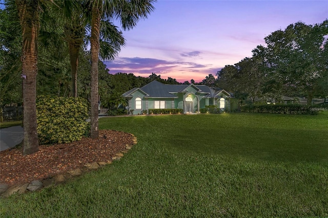 single story home featuring a lawn