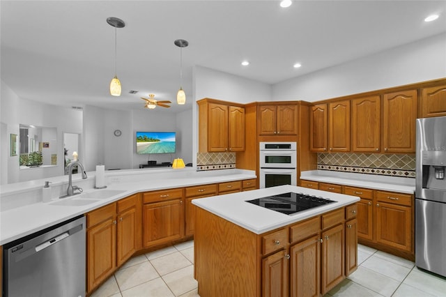 kitchen with ceiling fan, sink, tasteful backsplash, decorative light fixtures, and appliances with stainless steel finishes