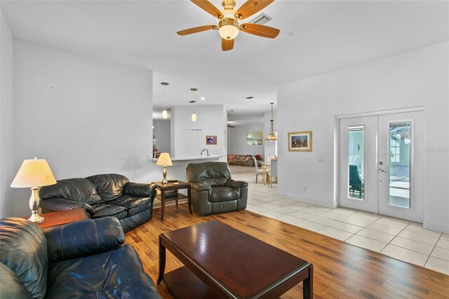 tiled living room featuring french doors and ceiling fan