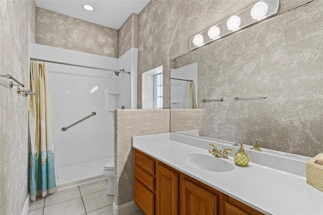 bathroom with tile patterned flooring, vanity, toilet, and walk in shower