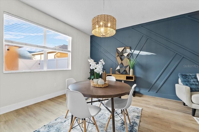 dining room featuring light wood-type flooring and an inviting chandelier