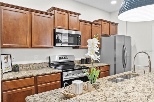 kitchen featuring light stone counters, sink, and appliances with stainless steel finishes