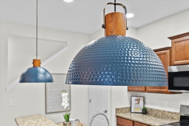 interior details featuring stove and hanging light fixtures