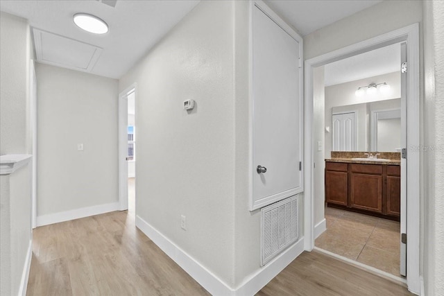 hallway with light hardwood / wood-style floors and sink