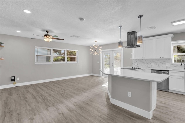 kitchen with plenty of natural light, white cabinets, stainless steel dishwasher, and ventilation hood