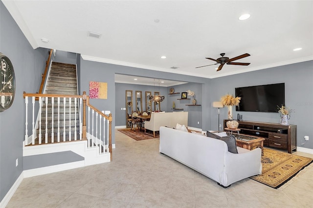 living room with ceiling fan with notable chandelier, light tile patterned floors, and crown molding