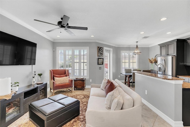 living room featuring ceiling fan, ornamental molding, light tile patterned floors, and plenty of natural light