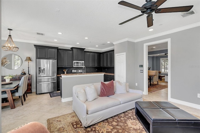 living room featuring ceiling fan with notable chandelier, light tile patterned flooring, and crown molding