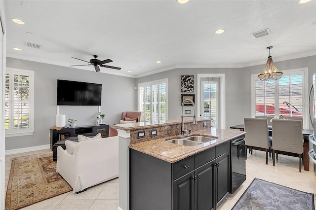 kitchen featuring decorative light fixtures, an island with sink, ceiling fan with notable chandelier, black dishwasher, and sink