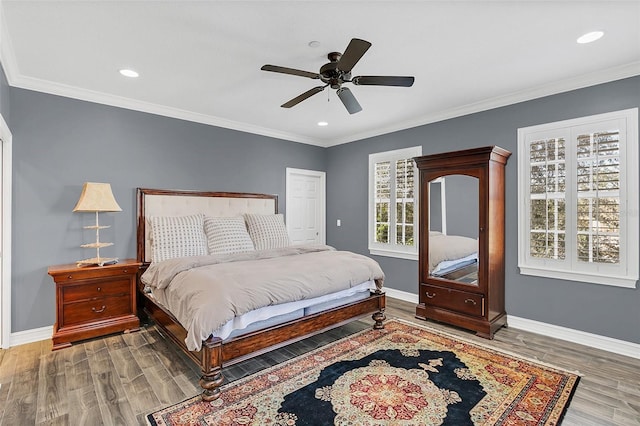 bedroom with dark hardwood / wood-style flooring, multiple windows, ceiling fan, and crown molding