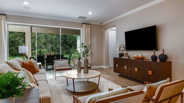 living room featuring a textured ceiling, light hardwood / wood-style flooring, and crown molding