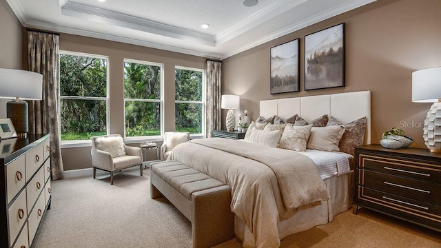 bedroom with ornamental molding, light carpet, and a tray ceiling