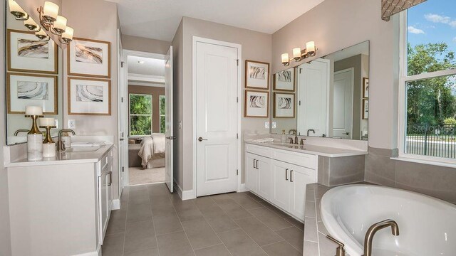 bathroom featuring vanity, a relaxing tiled tub, and plenty of natural light