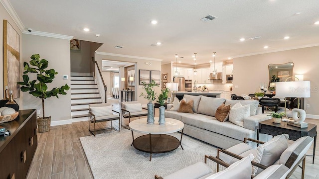 living room featuring crown molding and light hardwood / wood-style floors