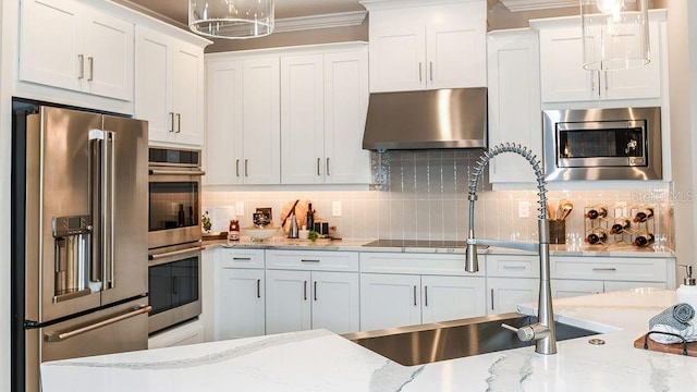 kitchen featuring backsplash, exhaust hood, white cabinets, hanging light fixtures, and stainless steel appliances