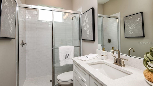 bathroom with an enclosed shower, vanity, and toilet