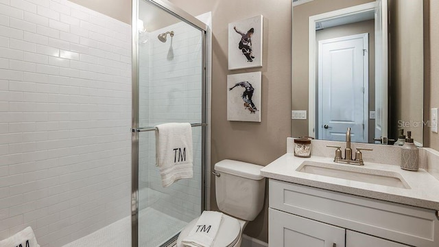 bathroom with vanity, toilet, and a shower with shower door