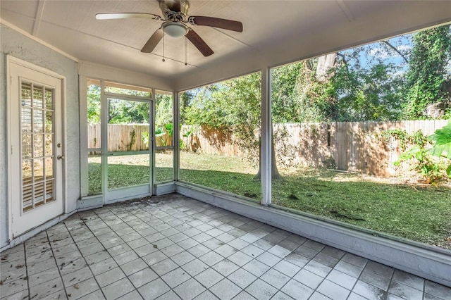 unfurnished sunroom with ceiling fan