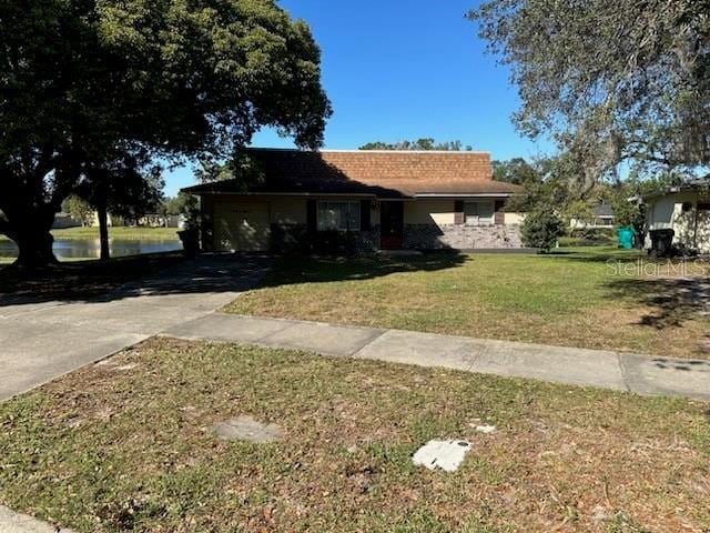 4518 Watch Hill Rd, Orlando, FL 32808 - ranch-style house with driveway, an attached garage, and a front yard