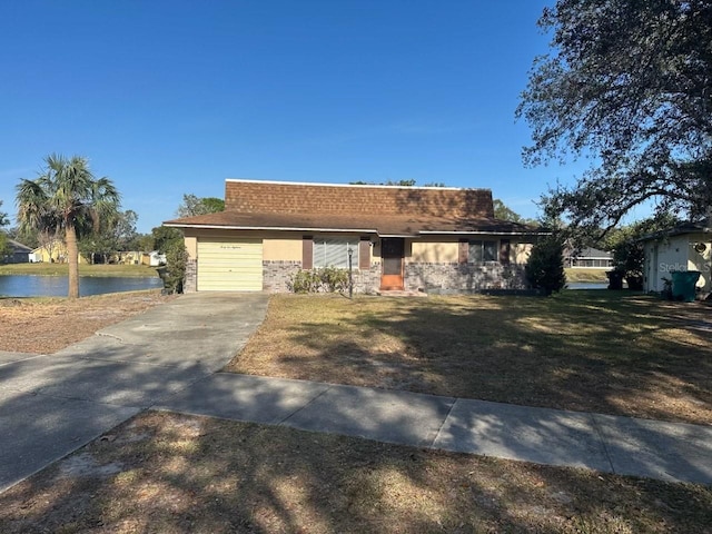 4518 Watch Hill Rd, Orlando, FL 32808 - view of front of house with a water view, a garage, driveway, and a front lawn
