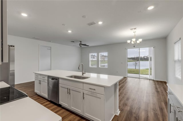 kitchen featuring ceiling fan with notable chandelier, stainless steel appliances, sink, decorative light fixtures, and a center island with sink