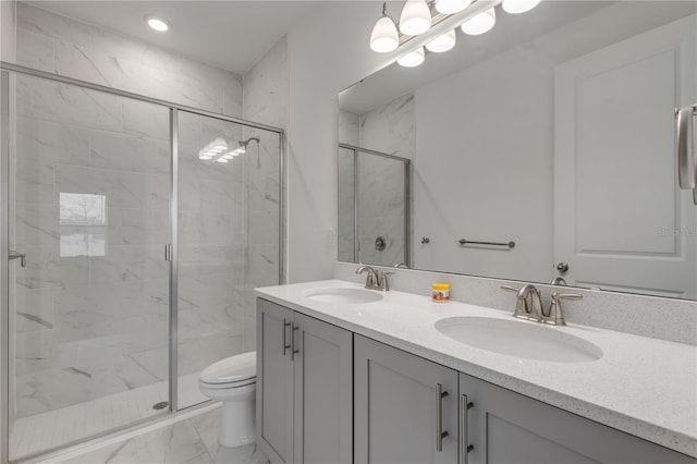 bathroom featuring a shower with door, vanity, and toilet