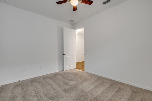 carpeted spare room featuring ceiling fan