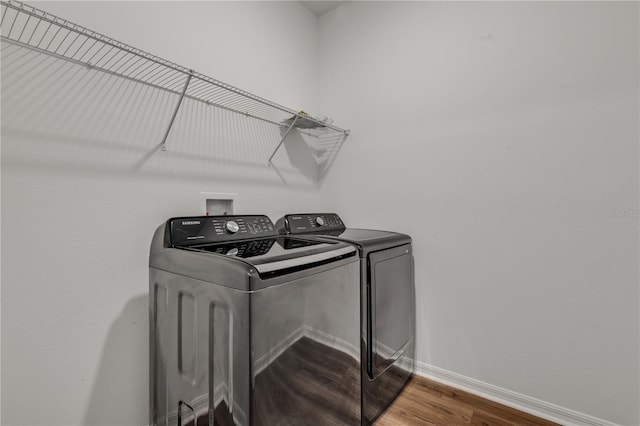 clothes washing area featuring hardwood / wood-style floors and washing machine and clothes dryer