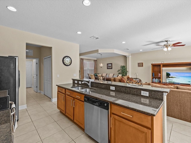 kitchen featuring appliances with stainless steel finishes, ceiling fan, dark stone countertops, and sink