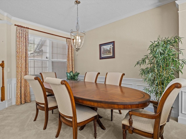 carpeted dining space with ornamental molding, a textured ceiling, and a chandelier