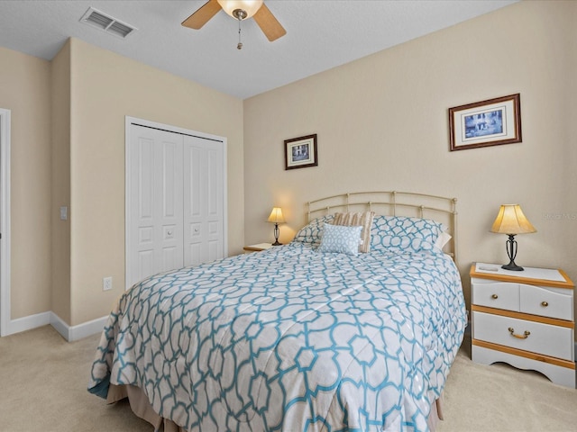 carpeted bedroom featuring ceiling fan and a closet